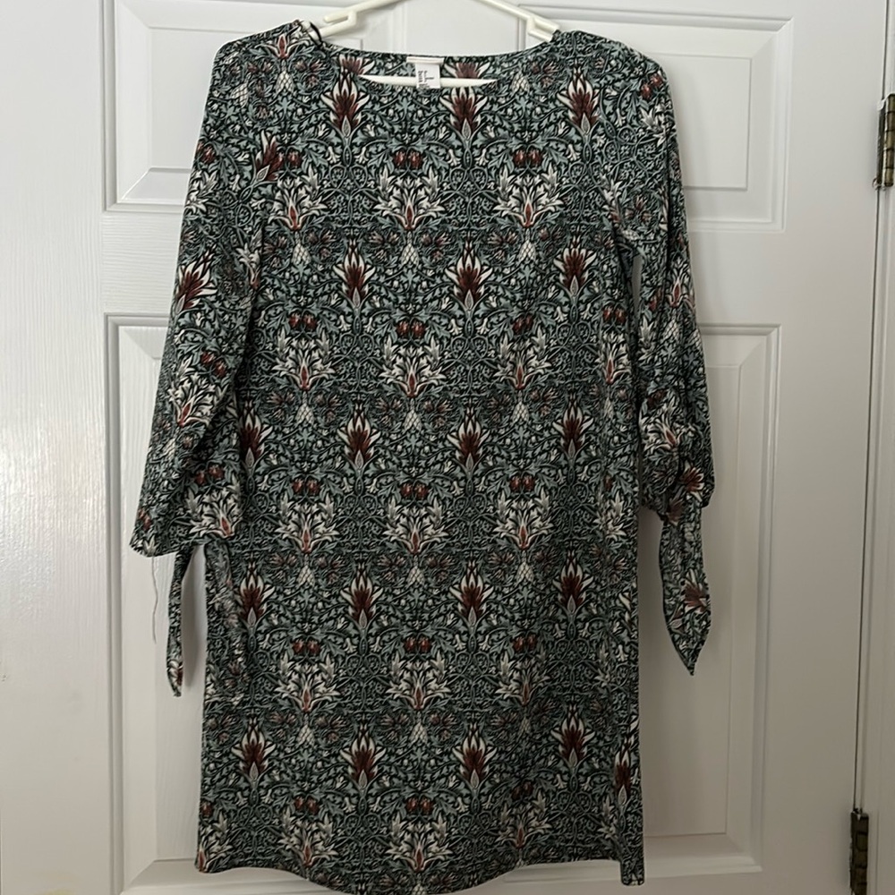 Patterned stylish dress with long sleeve flair sleeves that tie at the ends.